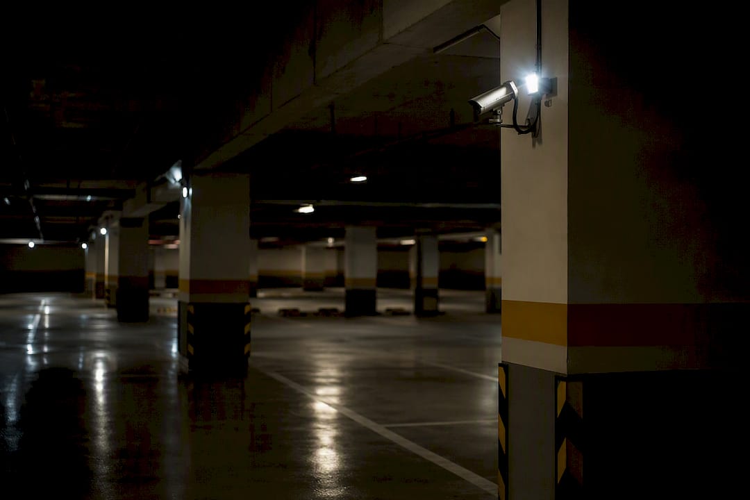 Dim condo parking with CCTV cameras
