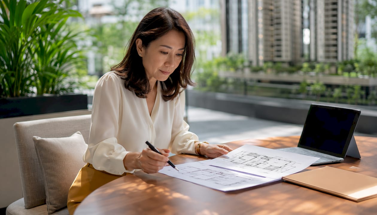 Buyer reviewing condo floor plans in sales gallery